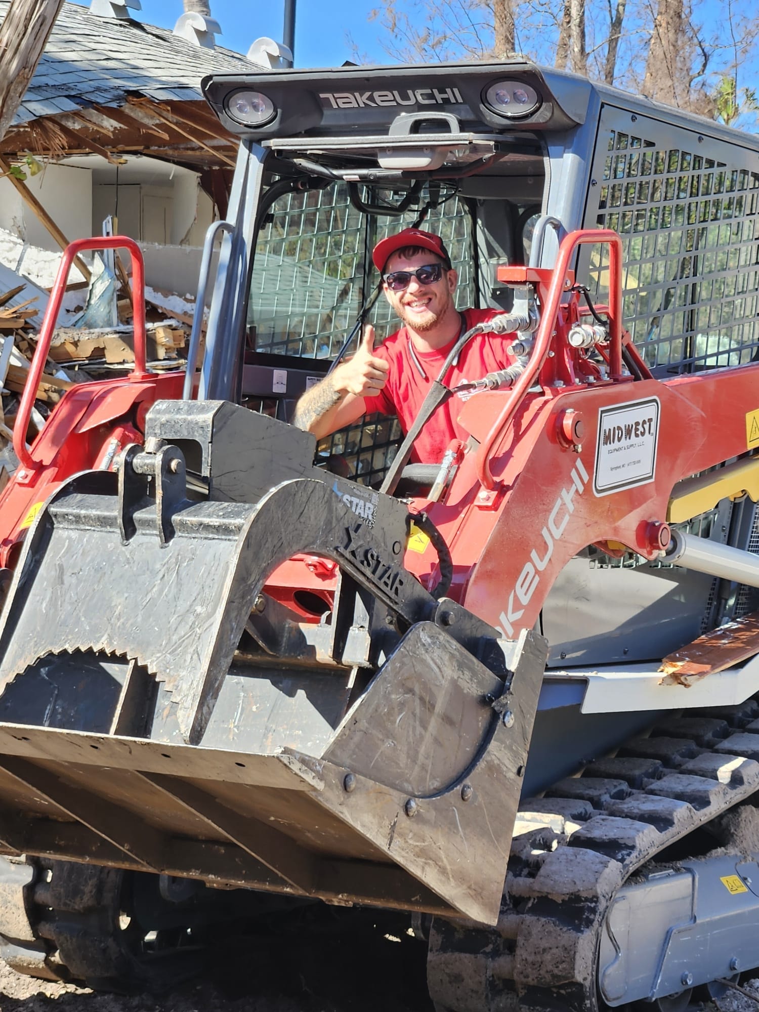 Right Choice Development crew member operating a compact track loader at a demolition site