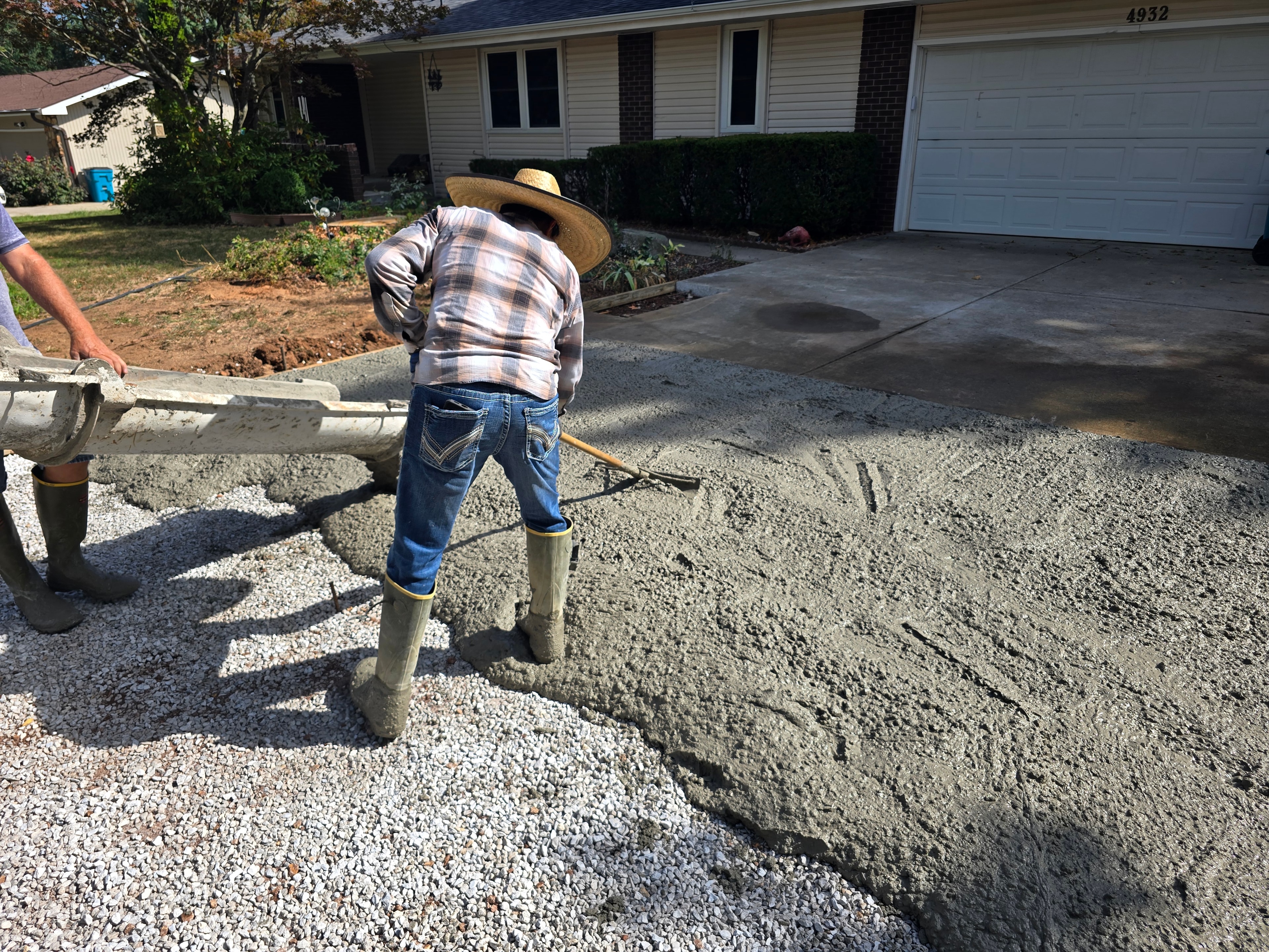 Construction crew pouring concrete for a residential driveway
