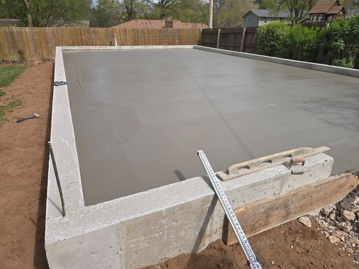 Concrete driveway finishing — worker troweling residential driveway in Springfield MO